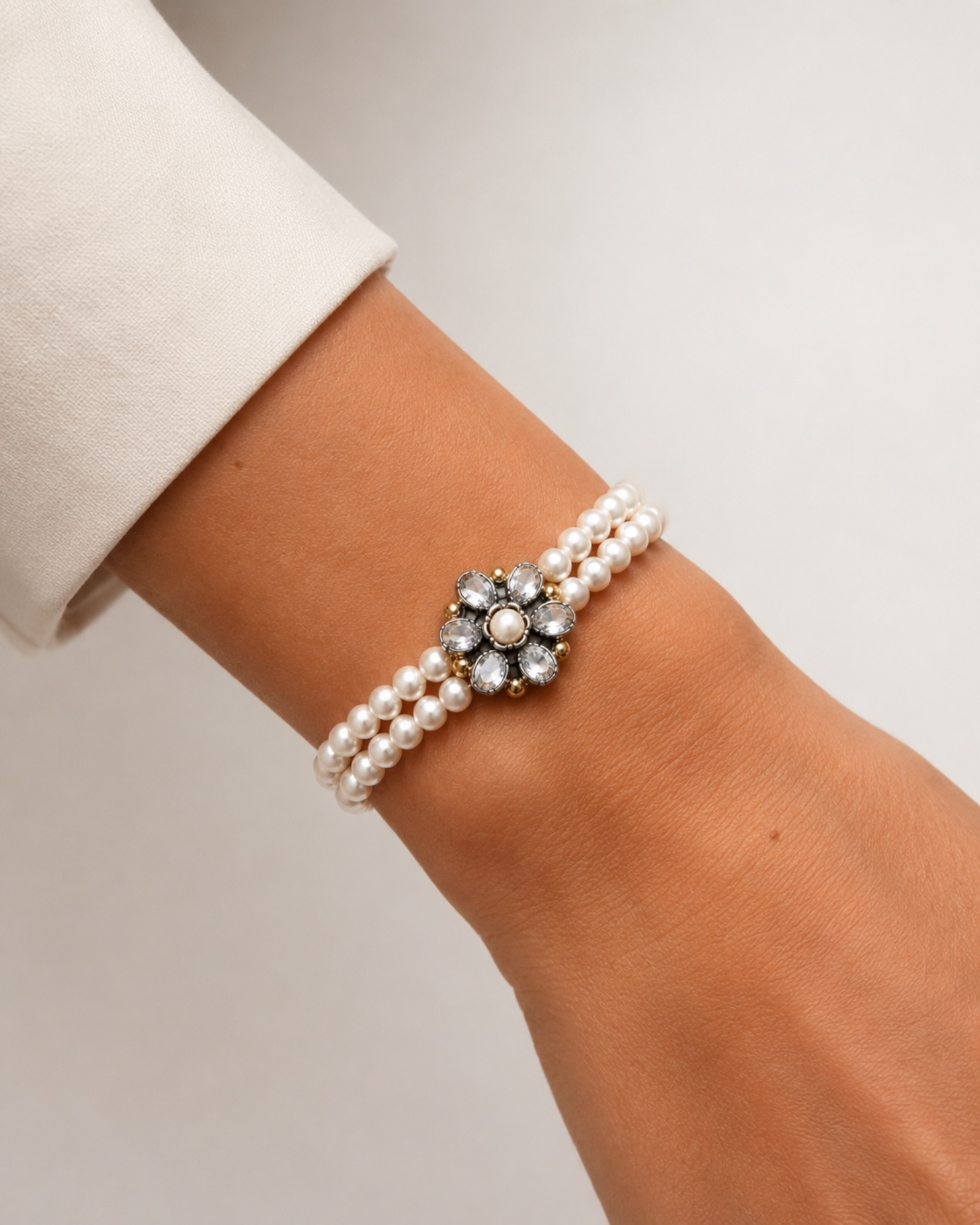 Pearl bracelet with flower in silver and gold.