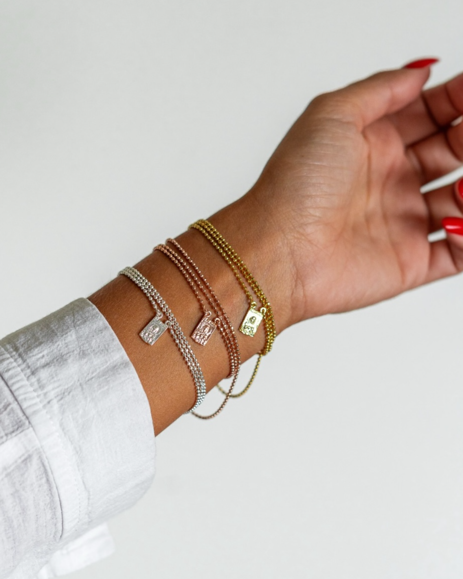 Escapulário curto em prata 925% com malha esfera e medalhas religiosas, pode ser usado como pulseira de três voltas.