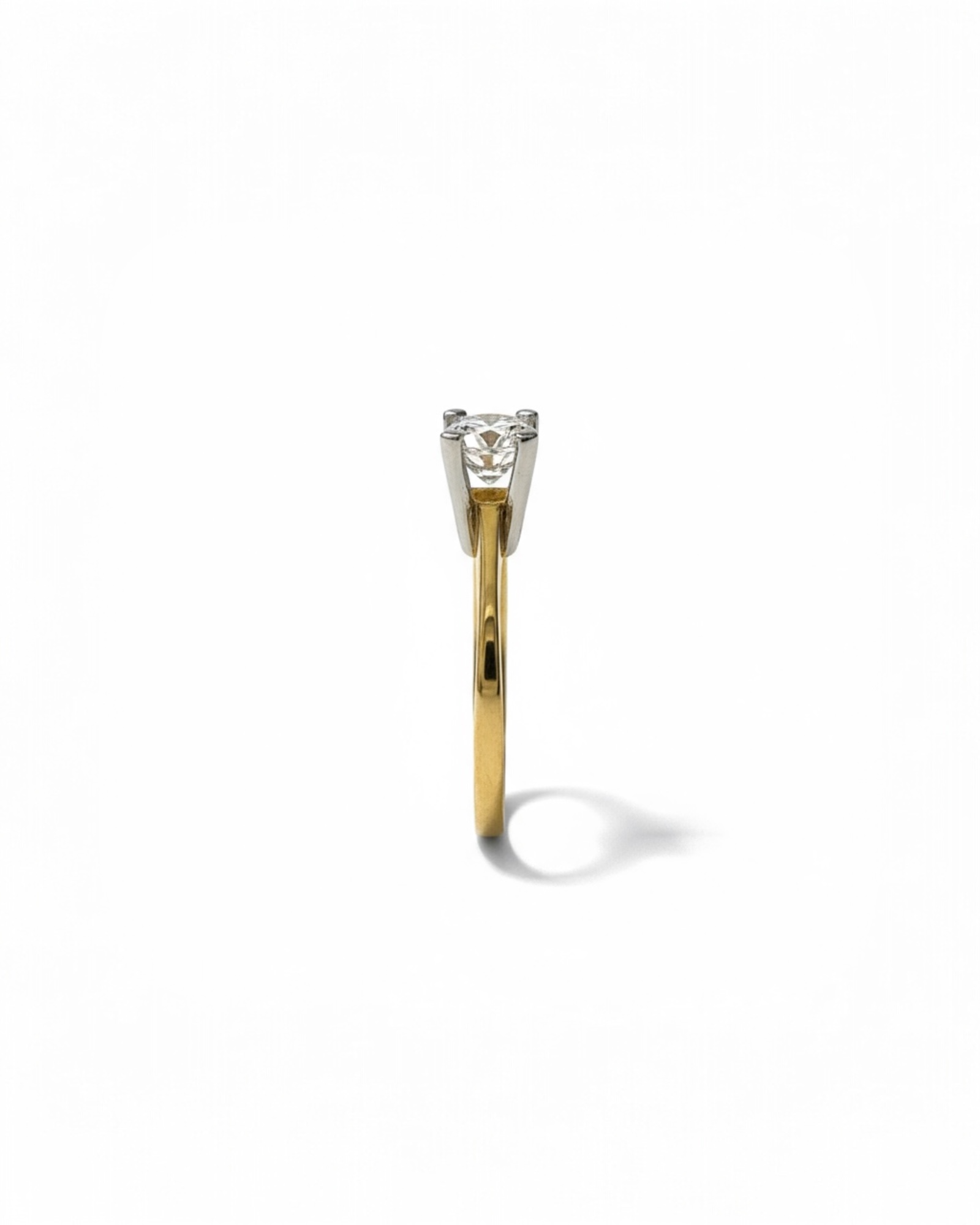 Solitaire engagement ring in white and yellow gold.