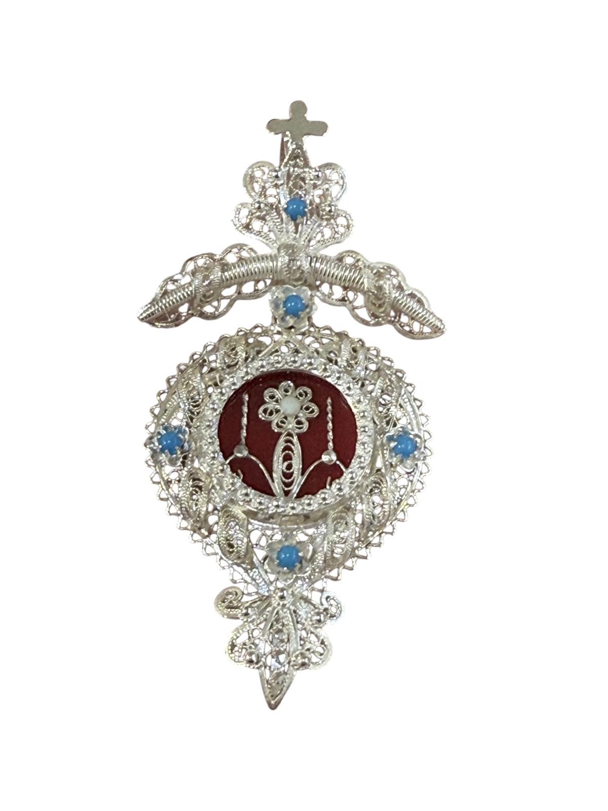 Medalha Custódia em filigrana com veludo vermelho ao centro e esmalte azul, disponível em prata branca ou dourada.
