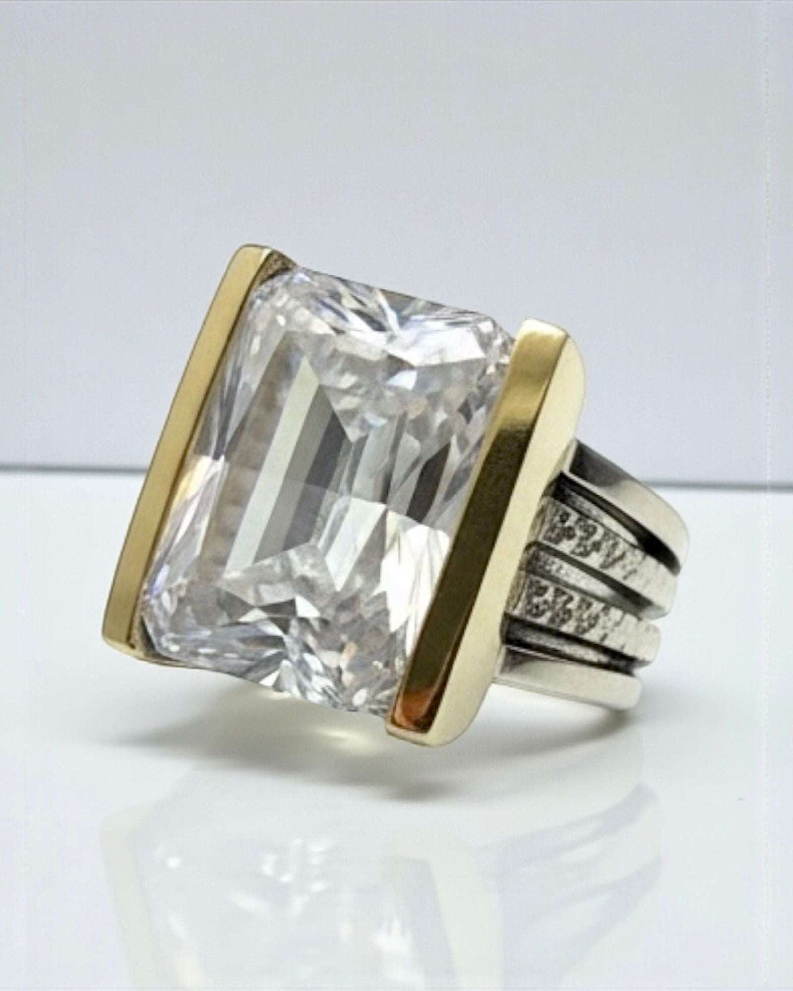 Silver and gold ring with a central stone.