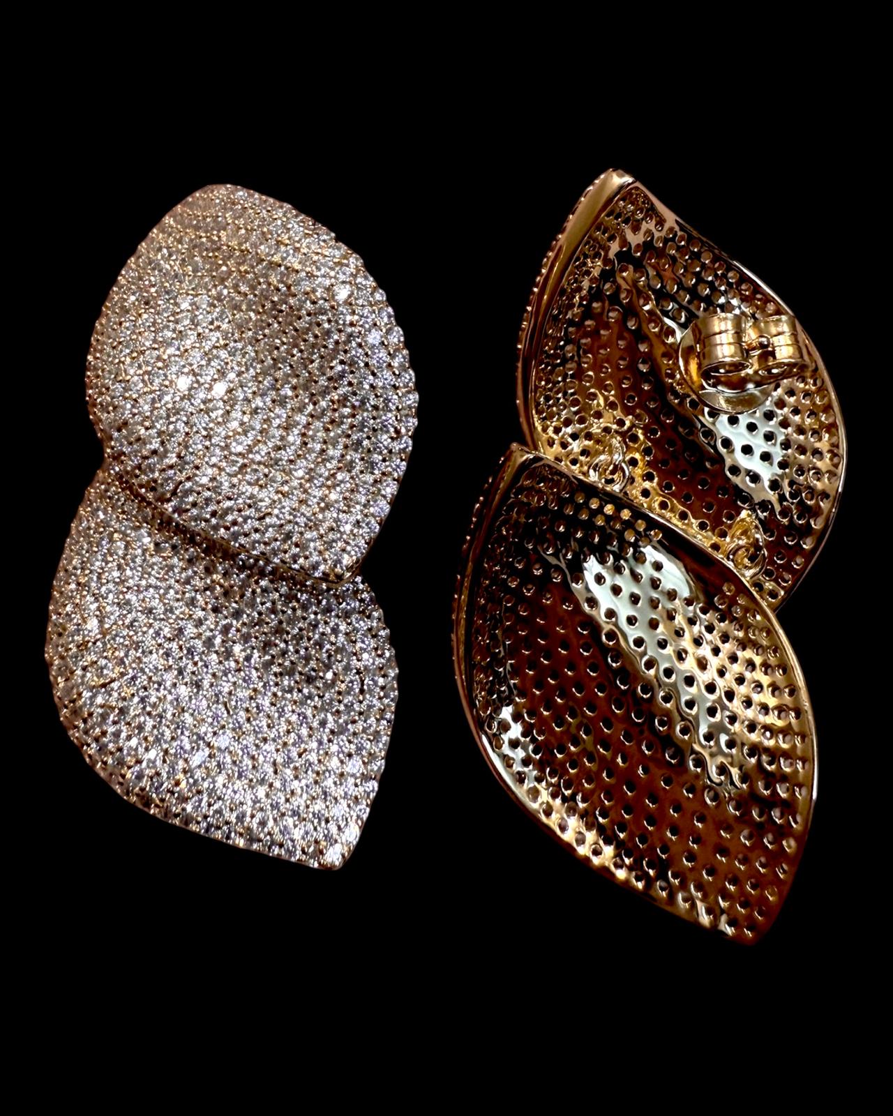 Brincos prata com duas pétalas curvas e textura brilhante

