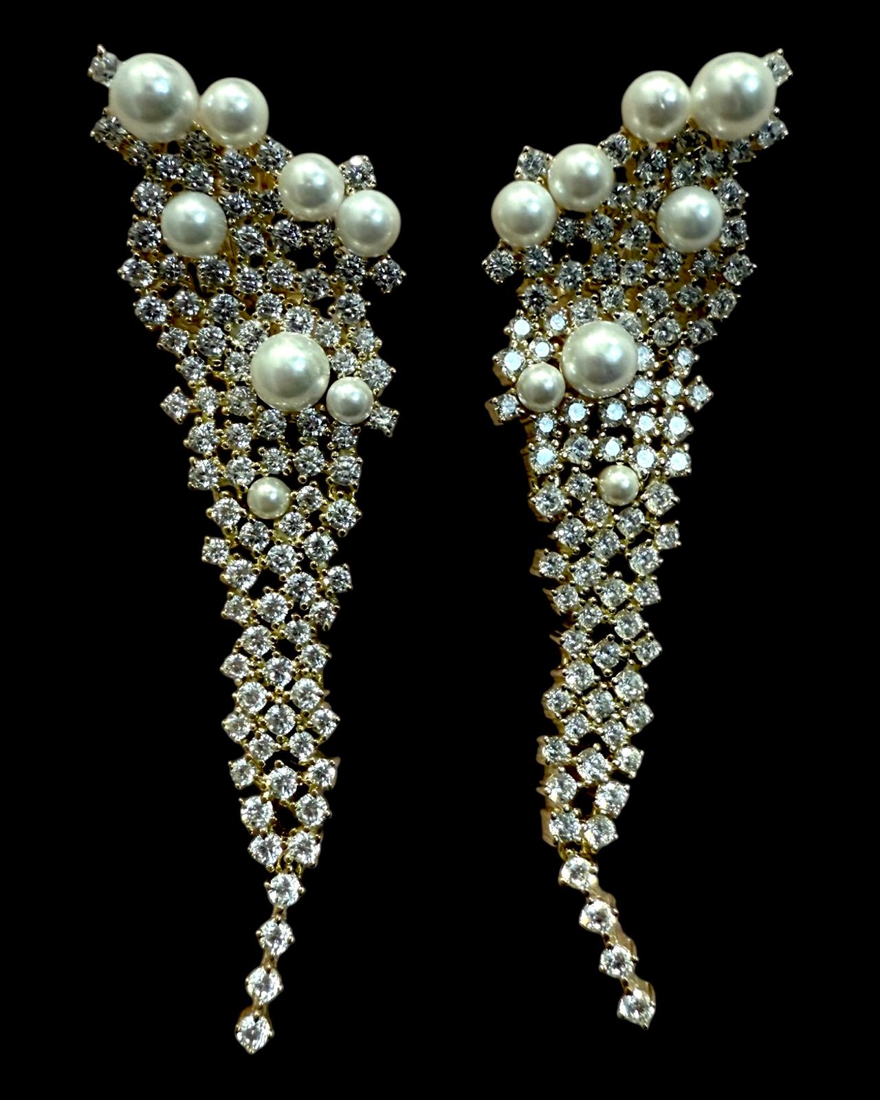 Brincos cascata em prata com pérolas e zircónias brilhantes, design assimétrico e elegante.
