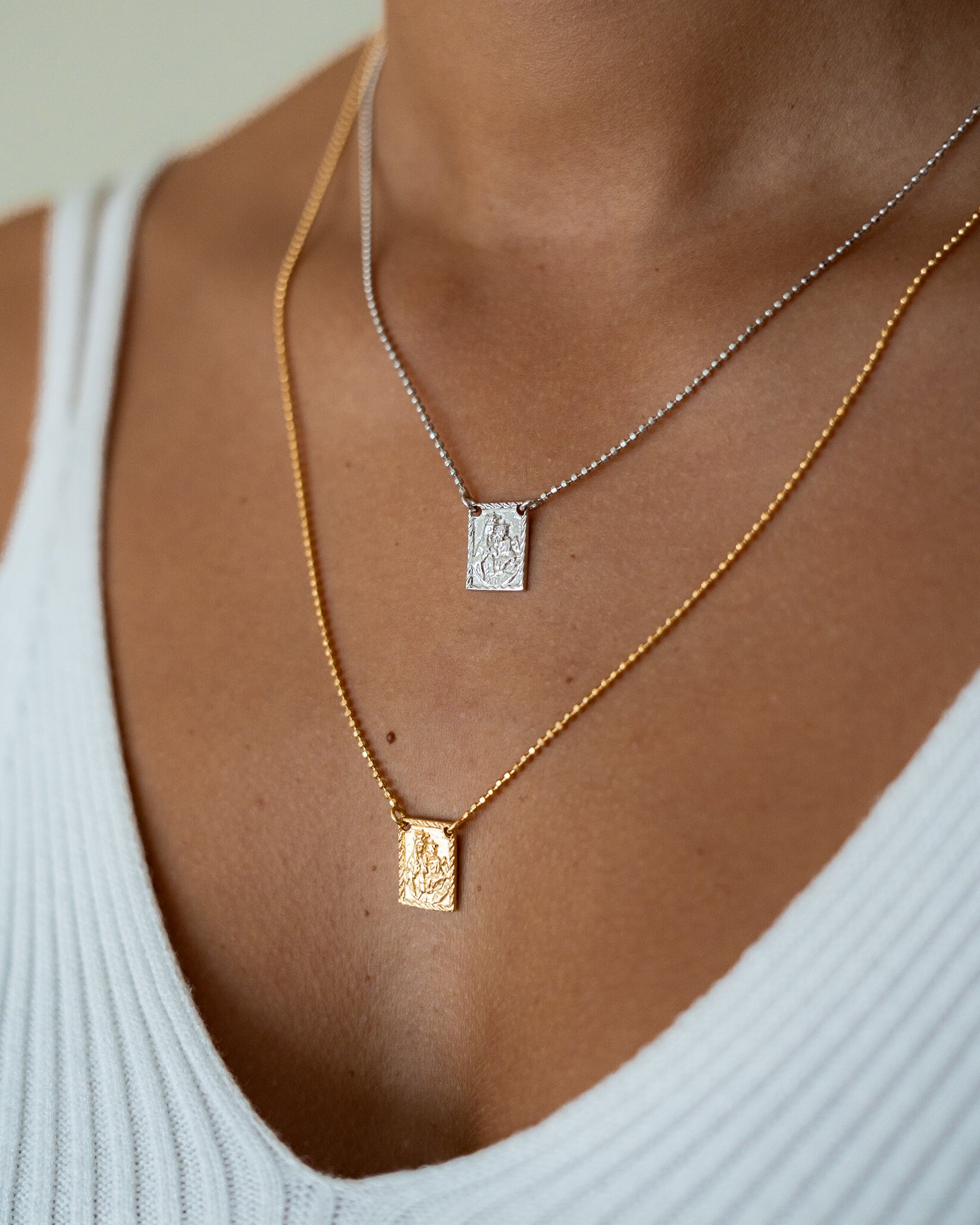 Escapulário comprido em prata dourada 925% com malha de esferas e medalhas religiosas.